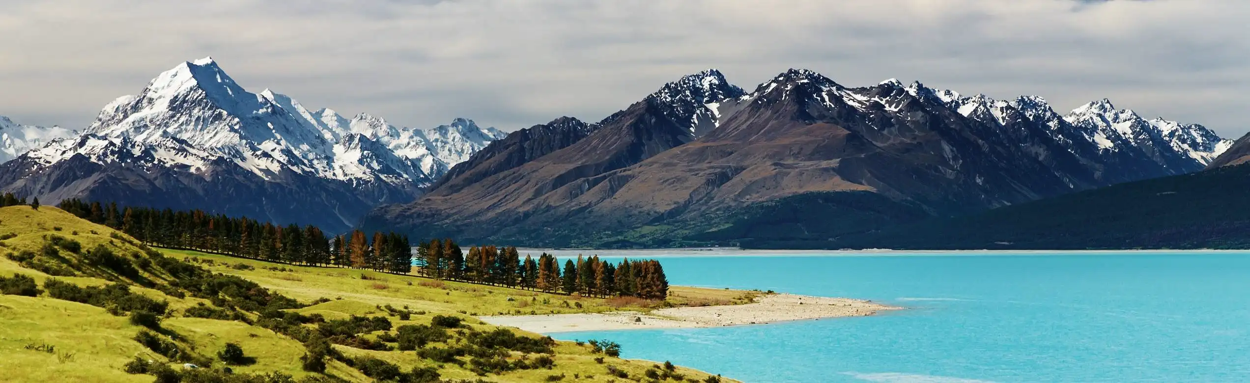 Panorama della Nuova Zelanda con lago turchese e montagne innevate delle Alpi Meridionali
