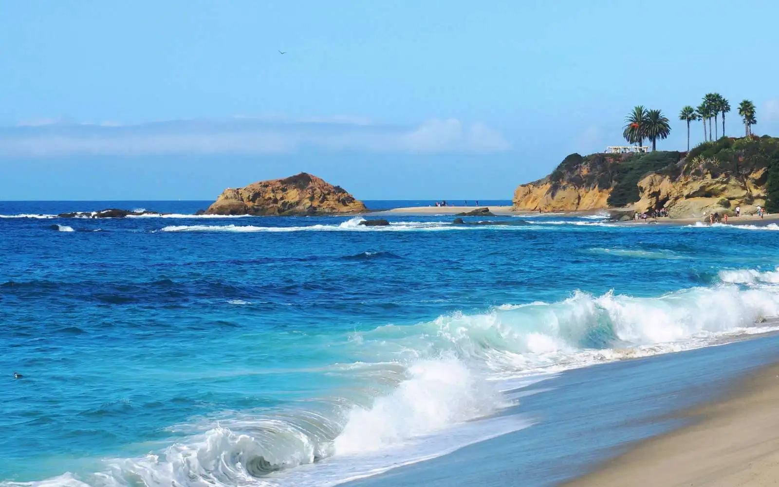 Spiaggia della California con sabbia dorata e onde dell'oceano Pacifico al tramonto