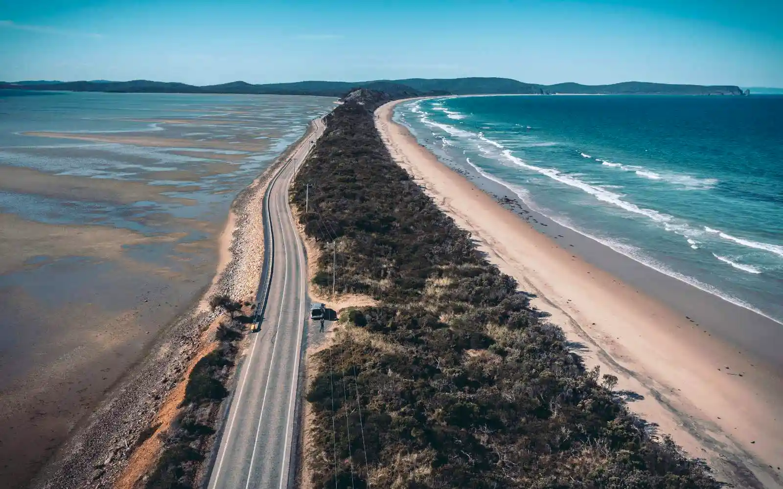 Strada panoramica in Tasmania tra colline, natura verde e cielo aperto
